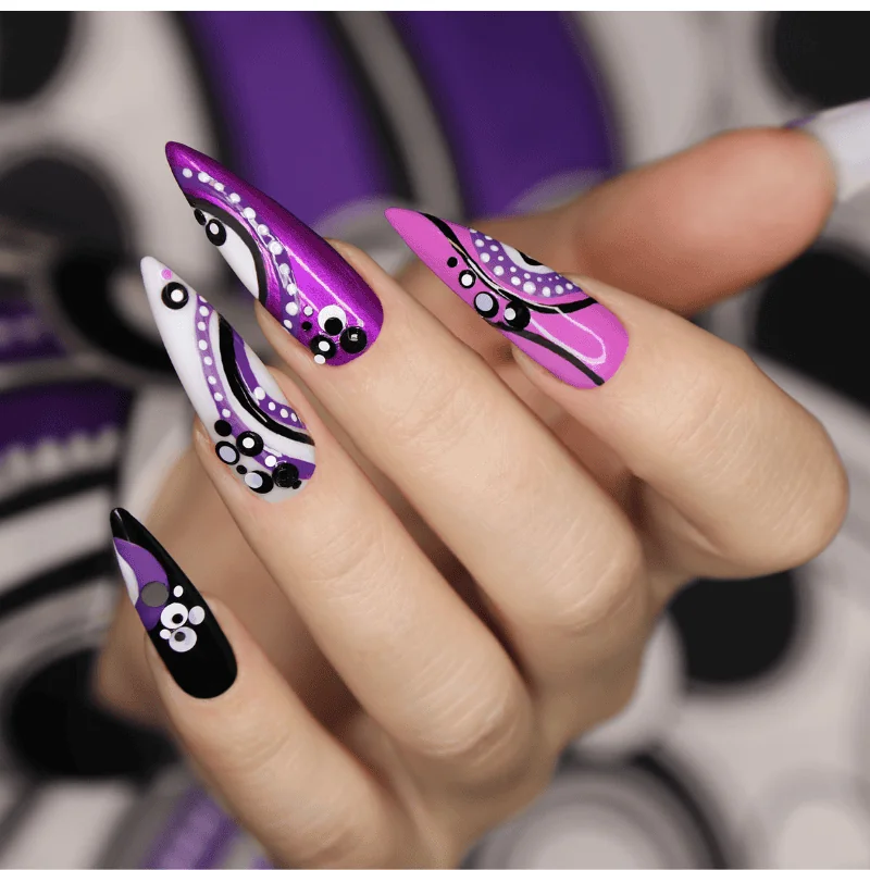 Abstract purple, black, and white nail art on stiletto-shaped nails – modern and bold design